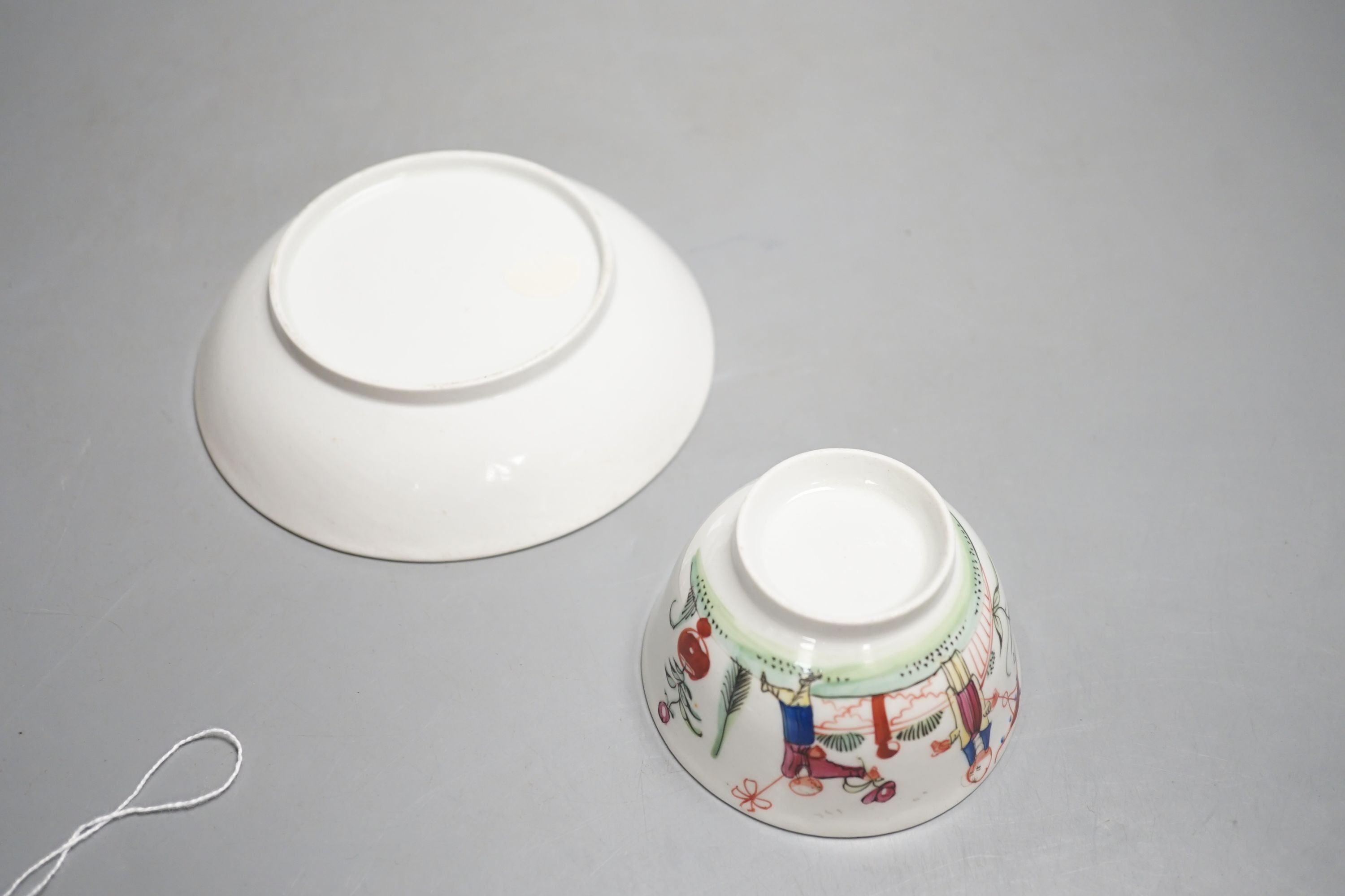 A New Hall teabowl and saucer painted with oriental children with either a pinwheel or a parasol pattern no. 20 and a cream jug painted with flowers pattern 253 C.1785